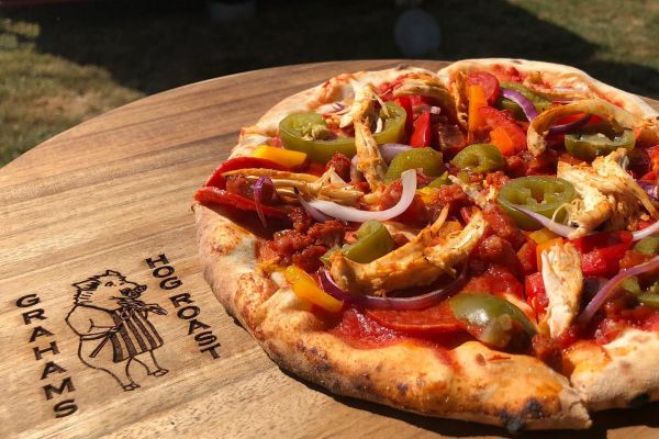 cooked pizza o0n a wooden board